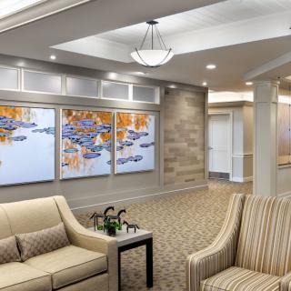 A modern lobby with comfortable seating and colorful artwork on the wall.