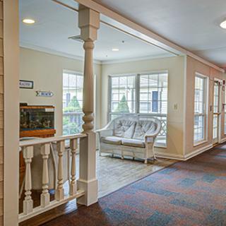 A bright hallway with a cozy waiting area and large windows letting in natural light.
