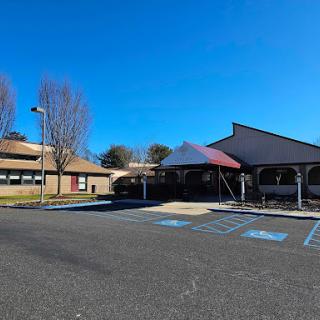 A bright, sunny day showcasing the architecture of a commercial building with an empty parking lot.