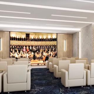 A modern theater with comfortable seating facing a stage.