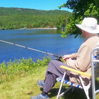 A person enjoys a peaceful day fishing by the lakeside.