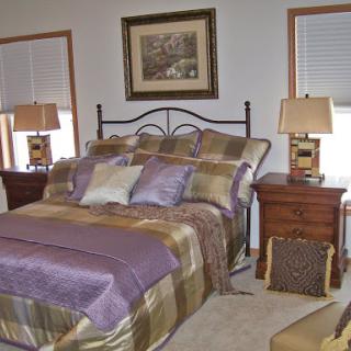 A beautifully decorated bedroom featuring elegant bedding and tasteful decor.