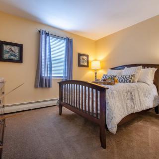 A cozy bedroom with a wooden bed frame, soft lighting, and decorative elements.