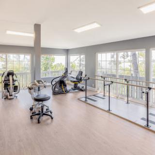 A bright and spacious gym filled with exercise equipment, offering a great environment for workouts.