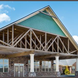 A modern building with a prominent triangular roof and stone facade.