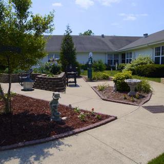 A beautifully landscaped garden with winding pathways and surrounding buildings.