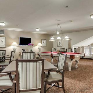 A modern game room featuring pool tables, a seating area, and a television.