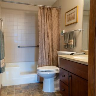 A clean and functional bathroom featuring a shower, toilet, and vanity.