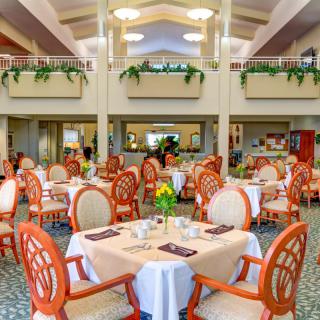A spacious and elegantly decorated dining room with multiple tables set for a meal.