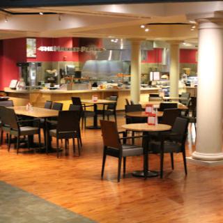 A spacious and inviting restaurant interior, featuring tables and chairs arranged for casual dining.