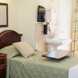 A tidy hospital room featuring a bed and medical equipment.