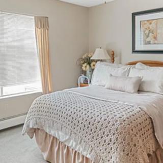 A cozy bedroom with a neatly made bed, soft lighting, and decorative elements.