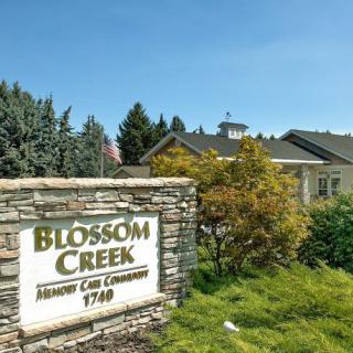 Blossom Creek Community with a prominent entrance sign surrounded by greenery.