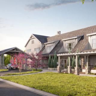 A charming residential house with a lush garden and blooming trees.
