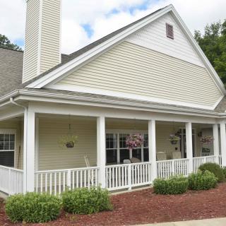 A charming single-story house with a front porch and neatly landscaped yard.
