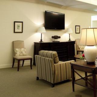 A cozy living room with comfortable seating, a television, and warm lighting.