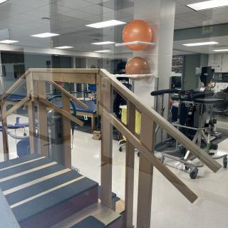 A physical therapy room with exercise equipment, including stairs and fitness tools.