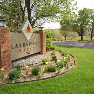 A welcoming entrance with a decorative sign and lush landscaping.