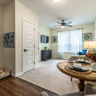 A cozy living room featuring a tasteful interior design, natural light streaming through the window, and a beautifully arranged table setting.
