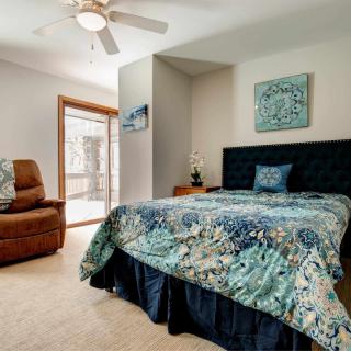 A cozy bedroom with a stylish bedspread and comfortable armchair.