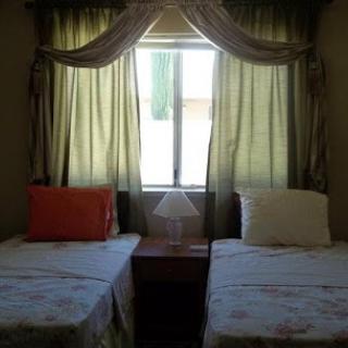 A cozy bedroom with twin beds and a window with curtains.