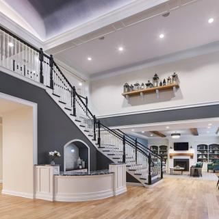 A modern and spacious living room with a stylish staircase leading to an upper level.