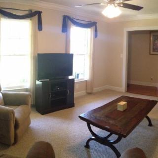 Cozy living room with a television, coffee table, and armchair.