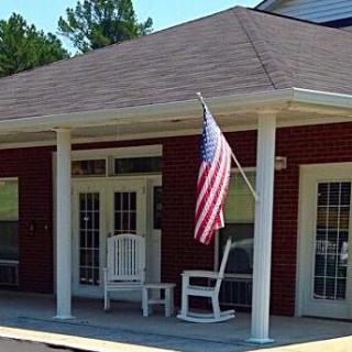 A porch with rocking chairs and an American flag on display.