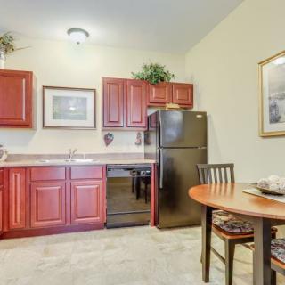 Cozy kitchen with red wooden cabinets and a small dining area.