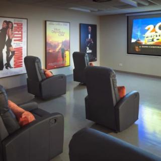 A cozy home theater setup with comfortable seating and movie posters on the walls.