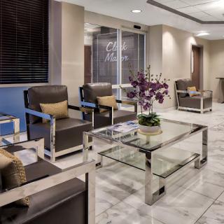A modern lobby with comfortable seating and a glass table adorned with a plant.