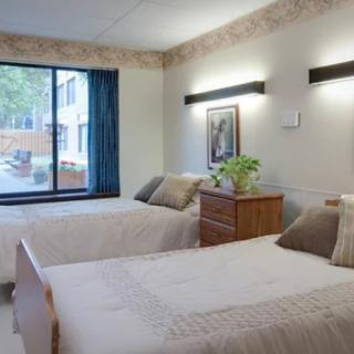 A neatly arranged bedroom with twin beds and minimalist decor.