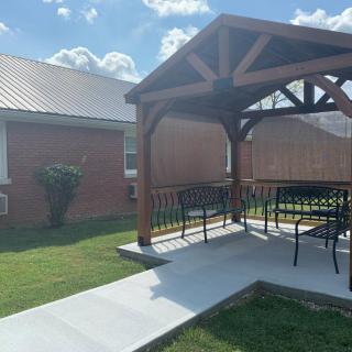 A sunny backyard patio with a gazebo and outdoor furniture.
