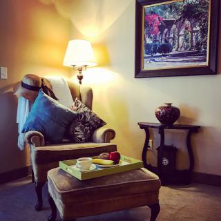 A cozy corner with an armchair, a side table, and decorative elements in a warmly lit living room.