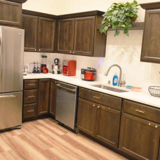 A cozy kitchen with wooden cabinets, stainless steel appliances, and a neatly organized countertop.