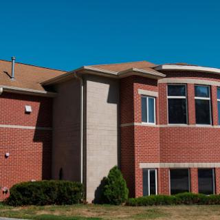 A modern brick building featuring multiple windows and a clear blue sky.