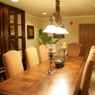 A beautifully arranged dining room featuring a wooden table and upholstered chairs, complemented by elegant lighting.