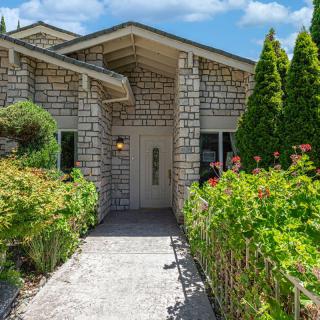 A charming house with a landscaped garden and inviting pathway leading to the entrance.