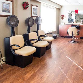 A cozy salon interior with hair dryers and a waiting area.