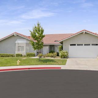 A suburban single-story house with a garage and a well-maintained lawn.