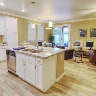 Modern open-concept kitchen and living area with an island and hardwood floors.