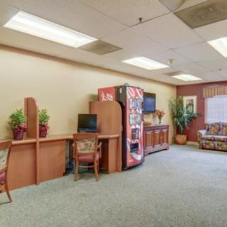 A spacious waiting room with a vending machine, computer station, and comfortable seating.