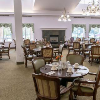 An elegant dining room with multiple tables and chairs set for service.