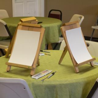 A table setup with easels and blank canvases ready for an art session.