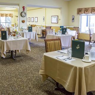 An elegant dining room setup with tables, chairs, and menus.