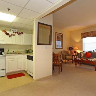 Cozy apartment interior featuring a small kitchen and a warmly decorated living room.