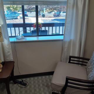 A cozy room corner with a chair and a table near the window.