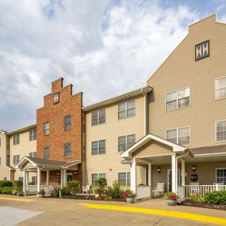 A view of a multi-story residential building with a brick and beige facade.