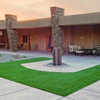 A modern courtyard featuring a central fountain, outdoor seating, and well-maintained landscaping.