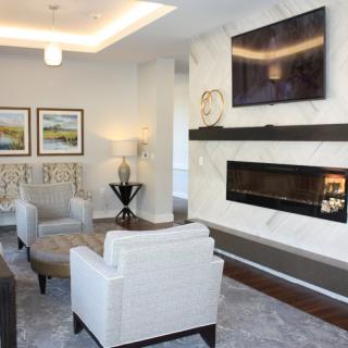 A modern living room featuring a sleek fireplace, mounted television, and comfortable seating area.